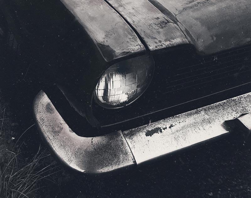 Scrap black car parked in a yard in Calgary to be towed by Cash 4 Junk Cars Calgary Junk Car Removal Service.